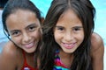 Beautiful Hispanic sisters by the pool
