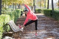 Beautiful hispanic sport woman in sportswear stretching leg on bench doing flexibility exercises warm up before running