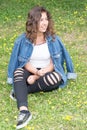 Beautiful Hispanic teen girl outdoors cute and smiling young woman with brown hair laughing and having fun in green grass Royalty Free Stock Photo