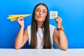 Beautiful hispanic woman holding paper plane and email symbol looking at the camera blowing a kiss being lovely and sexy