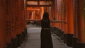 Beautiful hispanic woman, joyful in glasses, embraces freedom, smiling around fushimi torii gates, open arms aloft in life\'s Royalty Free Stock Photo