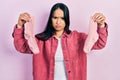 Beautiful hispanic woman with nose piercing holding socks skeptic and nervous, frowning upset because of problem Royalty Free Stock Photo