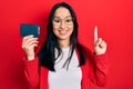 Beautiful hispanic woman with nose piercing holding ssd memory smiling with an idea or question pointing finger with happy face, Royalty Free Stock Photo