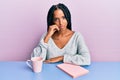 Beautiful hispanic woman reading a book and drinking a coffee thinking looking tired and bored with depression problems with Royalty Free Stock Photo