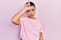 Beautiful hispanic woman with short hair wearing casual pink t shirt making fun of people with fingers on forehead doing loser Royalty Free Stock Photo