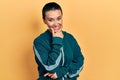 Beautiful hispanic woman with short hair wearing sporty jacket looking confident at the camera smiling with crossed arms and hand Royalty Free Stock Photo