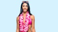 Beautiful hispanic woman wearing bikini and hawaiian lei sticking tongue out happy with funny expression Royalty Free Stock Photo