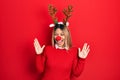 Beautiful hispanic woman wearing deer christmas hat and red nose celebrating mad and crazy for success with arms raised and closed Royalty Free Stock Photo