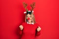 Beautiful hispanic woman wearing deer christmas hat and red nose excited for success with arms raised and eyes closed celebrating Royalty Free Stock Photo