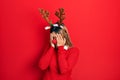 Beautiful hispanic woman wearing deer christmas hat and red nose with sad expression covering face with hands while crying Royalty Free Stock Photo