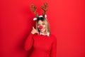 Beautiful hispanic woman wearing deer christmas hat and red nose smiling doing phone gesture with hand and fingers like talking on Royalty Free Stock Photo