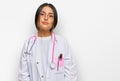 Beautiful hispanic woman wearing doctor uniform and stethoscope relaxed with serious expression on face Royalty Free Stock Photo