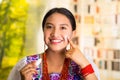 Beautiful hispanic woman wearing white blouse with colorful embroidery, applying cream onto face using finger during Royalty Free Stock Photo