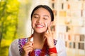 Beautiful hispanic woman wearing white blouse with colorful embroidery, applying cream onto face using finger during Royalty Free Stock Photo