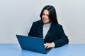 Beautiful hispanic woman working at the office with laptop clueless and confused expression Royalty Free Stock Photo