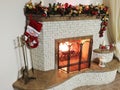 Beautiful holdiay decorated room with Christmas tree. Burning fireplace. Decorated festive fireplace with burning fire Royalty Free Stock Photo