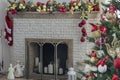 Beautiful holdiay decorated room with Christmas tree. Burning fireplace. Decorated festive fireplace with burning fire