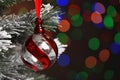 Beautiful holiday bauble hanging on Christmas tree against blurred festive lights, closeup. Space for text Royalty Free Stock Photo