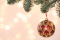 Beautiful holiday bauble hanging on Christmas tree against blurred lights, closeup. Space for text Royalty Free Stock Photo