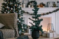 Beautiful holiday decorated room with Christmas tree, fireplace and armchair with blanket Royalty Free Stock Photo