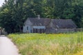 A historic farmhouse and farm buildings in the Holy Cross Mountains among greenery .