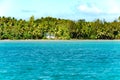 House in tropical paradise directly on clear turquoise water, surrouned by palm trees, South Pacific Ocean, Aitutaki, Cook Islands Royalty Free Stock Photo