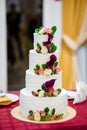 Beautiful home wedding four-tiered cake decorated with spring red flowers and handmade pattern. The concept of delicious Royalty Free Stock Photo