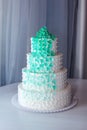 Beautiful home wedding four-tiered cake decorated with turquoise flowers on white table Royalty Free Stock Photo