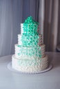 Beautiful home wedding four-tiered cake decorated with turquoise flowers on white table Royalty Free Stock Photo