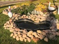 Beautiful homemade stone pond of cobblestones on the street under the open sky. Homemade landscape design