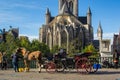 Beautiful horse carriage with the facade of Saint Nicholas` Church Sint-Niklaaskerk and the clock tower of Former Post Office a