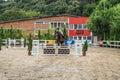 Beautiful horse and jokey in action at horse race track with obstacle equipment at hippodrome