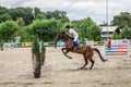 Beautiful horse and jokey in action at horse race track with obstacle equipment at hippodrome Royalty Free Stock Photo