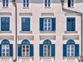 Beautiful house facade with white windows and blue wooden shutters, Hallein, Austria Royalty Free Stock Photo