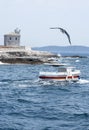 Beautiful house and tower of white lighthouse. Elements voyage. Seascape, ship with red and white striped, coast. Bird flies