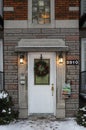 Beautiful houses in city of Montreal. Winter time. Christmas decorated white door Royalty Free Stock Photo