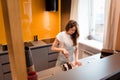 Beautiful housewife cutting bacon on wooden board on kitchen