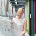 Beautiful housewife buying white curtains in home decor furnishings store. Royalty Free Stock Photo