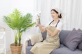 Beautiful housewife is cleaning things and vases in the living room