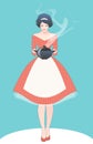 Beautiful housewife dressed in the style of the 50s in a polka dot dress, carrying a steaming pot