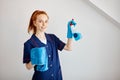 Beautiful housewife holds cleaning tools and shows bottle Royalty Free Stock Photo