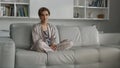 Beautiful housewife posing sofa in pajamas before breakfast. Girl relaxing alone Royalty Free Stock Photo