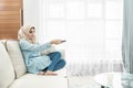 beautiful housewife wearing hijab watching television in a leisu Royalty Free Stock Photo