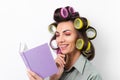 Beautiful housewife. Young cheerful woman with curlers Royalty Free Stock Photo