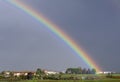 A beautiful rainbow against a dark sky overlooks the Tuscan countryside