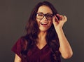 Beautiful humor loud toothy enjoying laughing woman with long brown healthy curly hair style holding the hand the glasses in dark