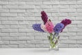 Beautiful hyacinths in glass vase on table against wall, space for text. Spring flowers Royalty Free Stock Photo