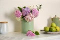 Beautiful hydrangea flowers and apples on countertop