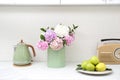 Beautiful hydrangea flowers, kettle and apples on countertop