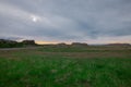 Beautiful icelandic landscape in early morning. Green grass, yellow sunrise, clouds and road in the distance. Very beautiful Royalty Free Stock Photo